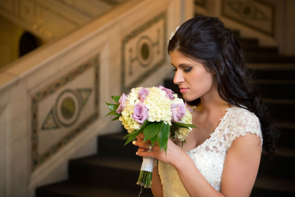bride standin on the staircase in Chicago Cultural Center with flowers. 