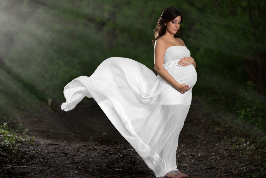 Maternity photo of a lady in a dress caught in the wind.