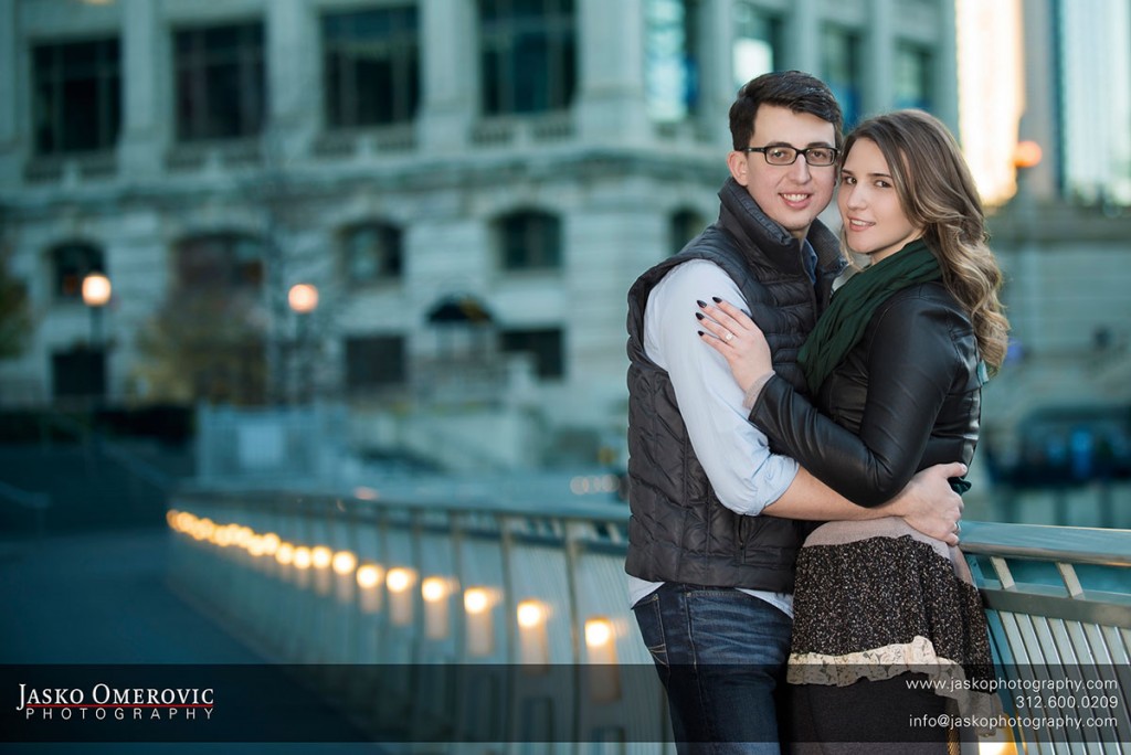 chicago engagement session with a couple hugging and line of lights behind them.