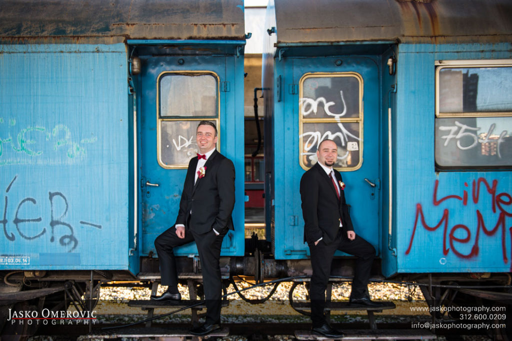 groom and his best man standing on the car of the decayed train