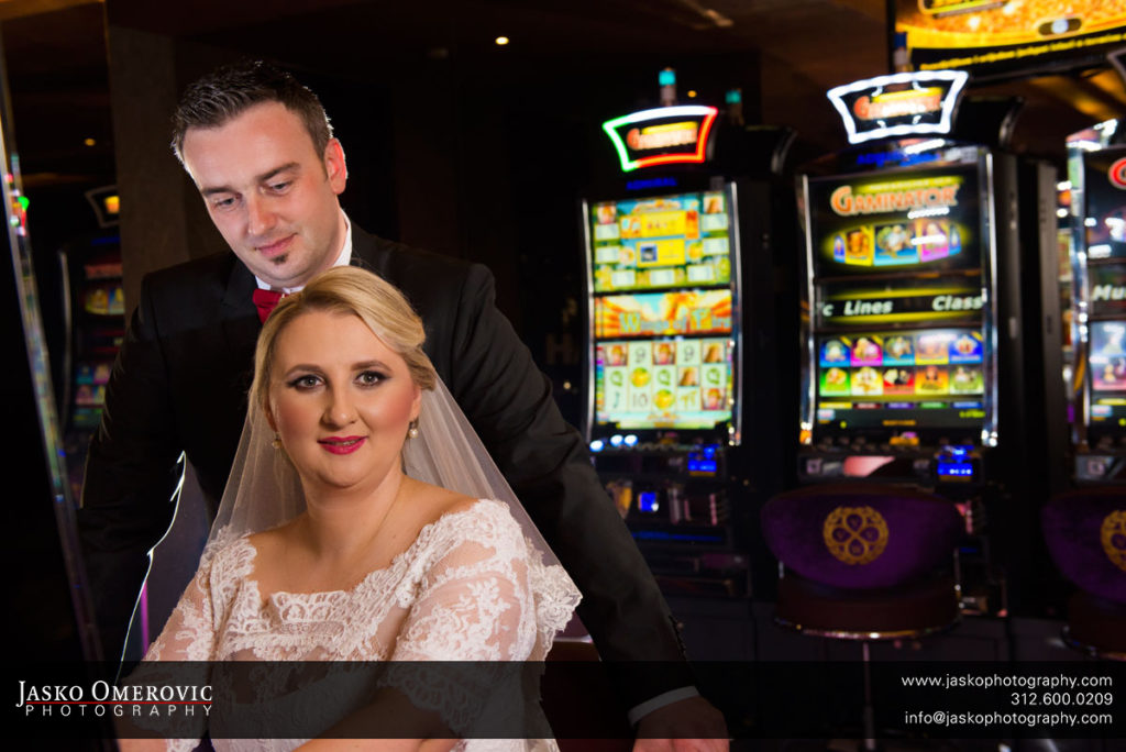 Bride and Groom in The Casino behind the slot machine.