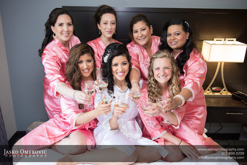 bridesmaids in pink around the pride toasting before the wedding