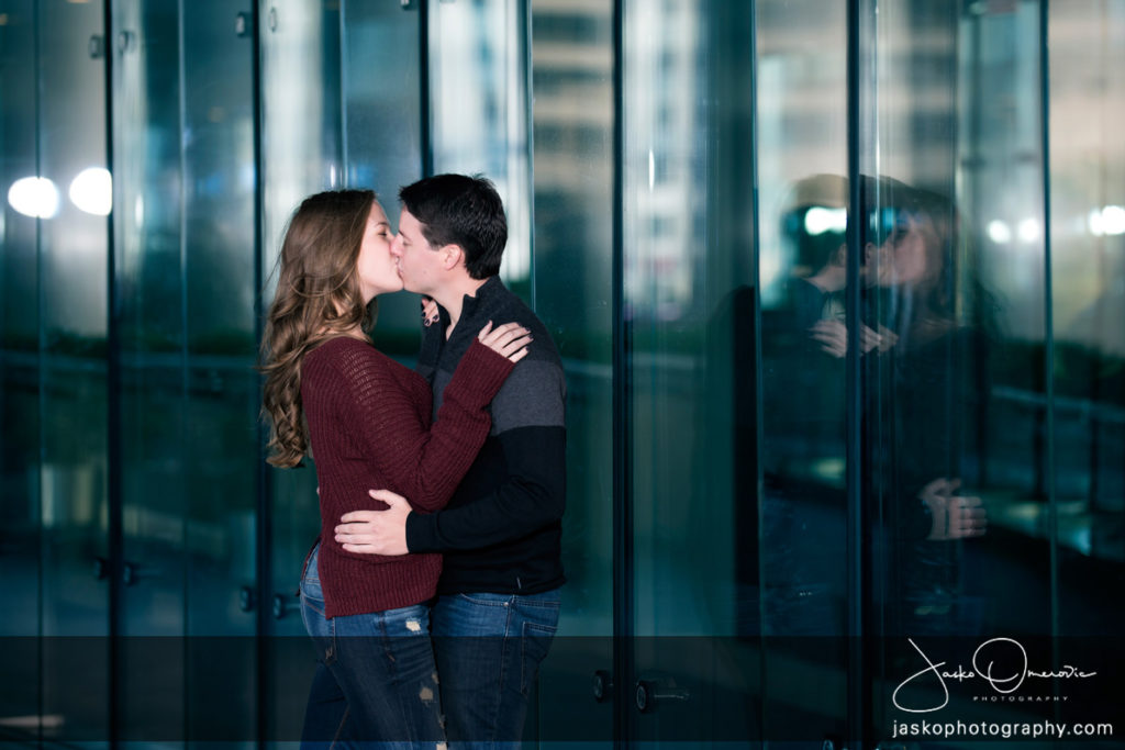 Engagement Session Couple Kissing Leaning Against Glass