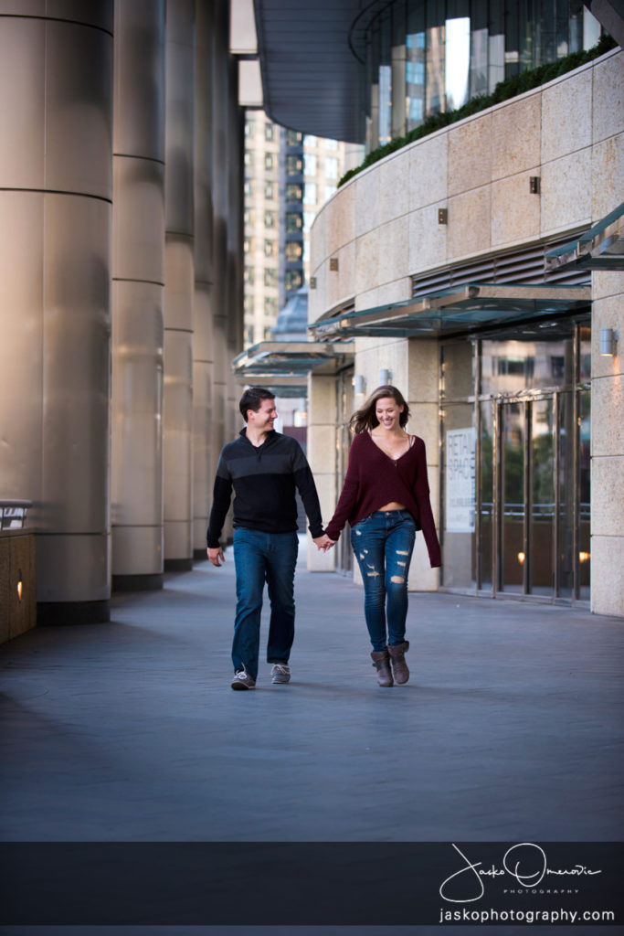 Engaged Couple Walking with pillars in the background