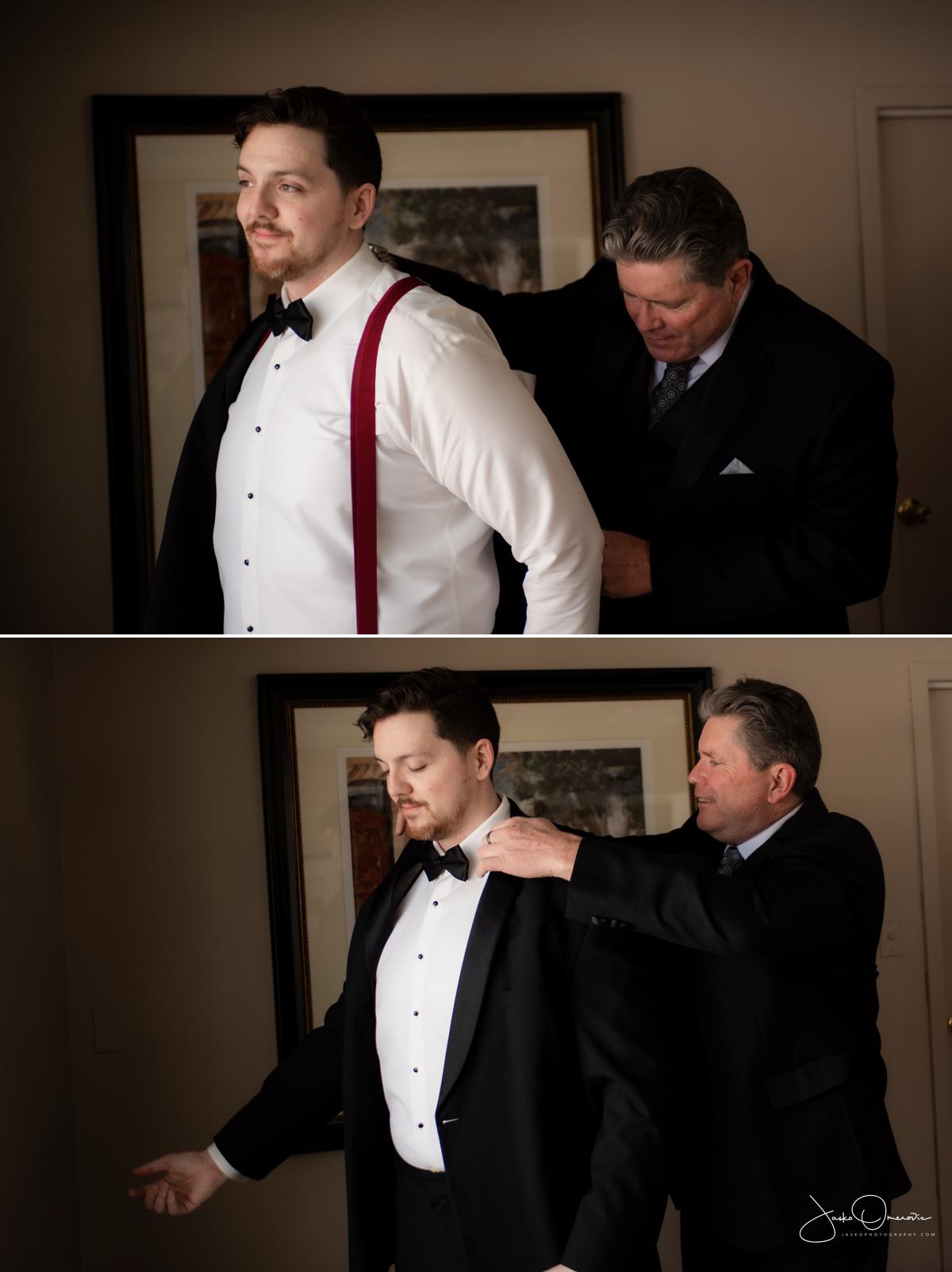 father helping a groom put his wedding coat on