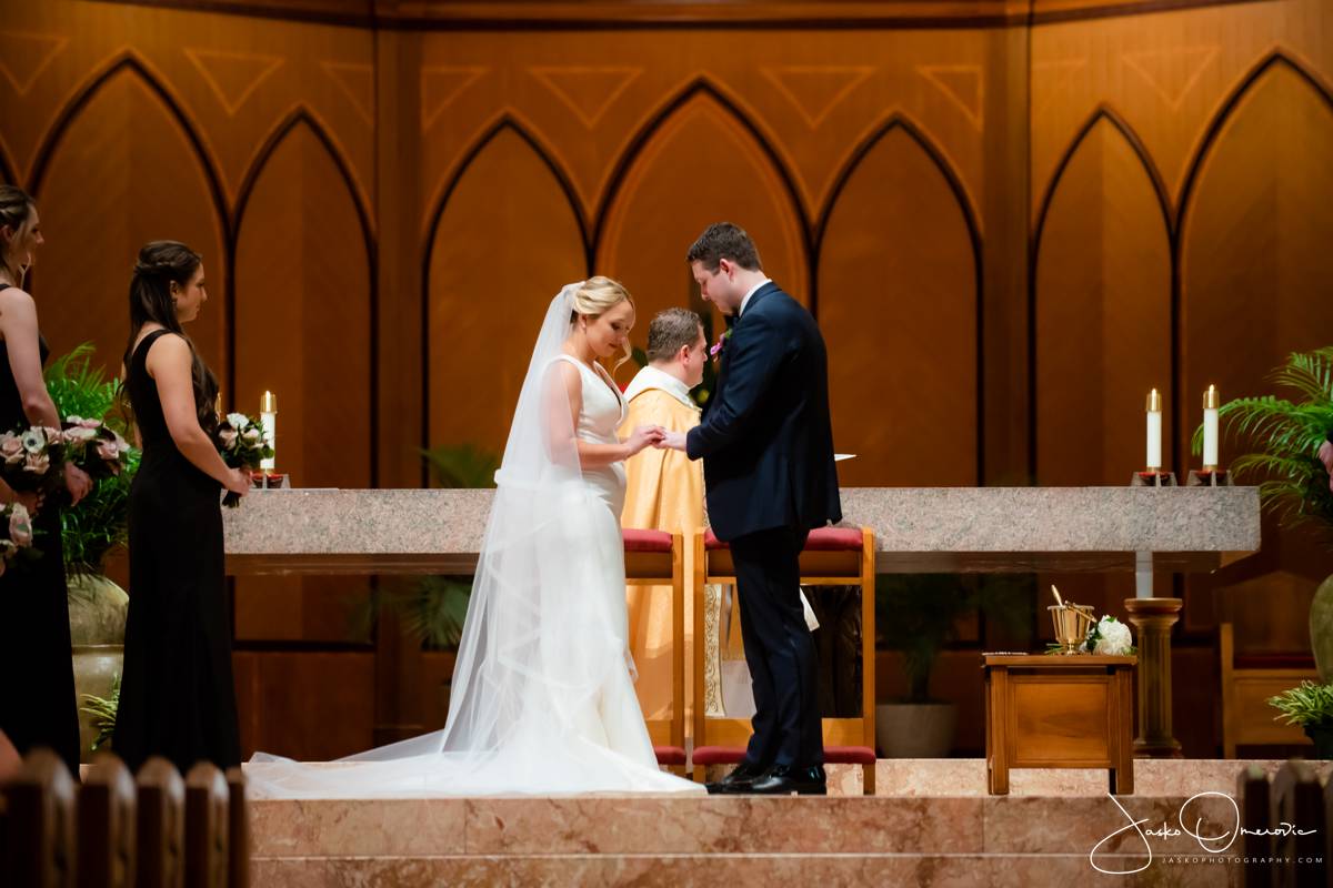 bride and groom putting rings on during chicago wedding ceremony