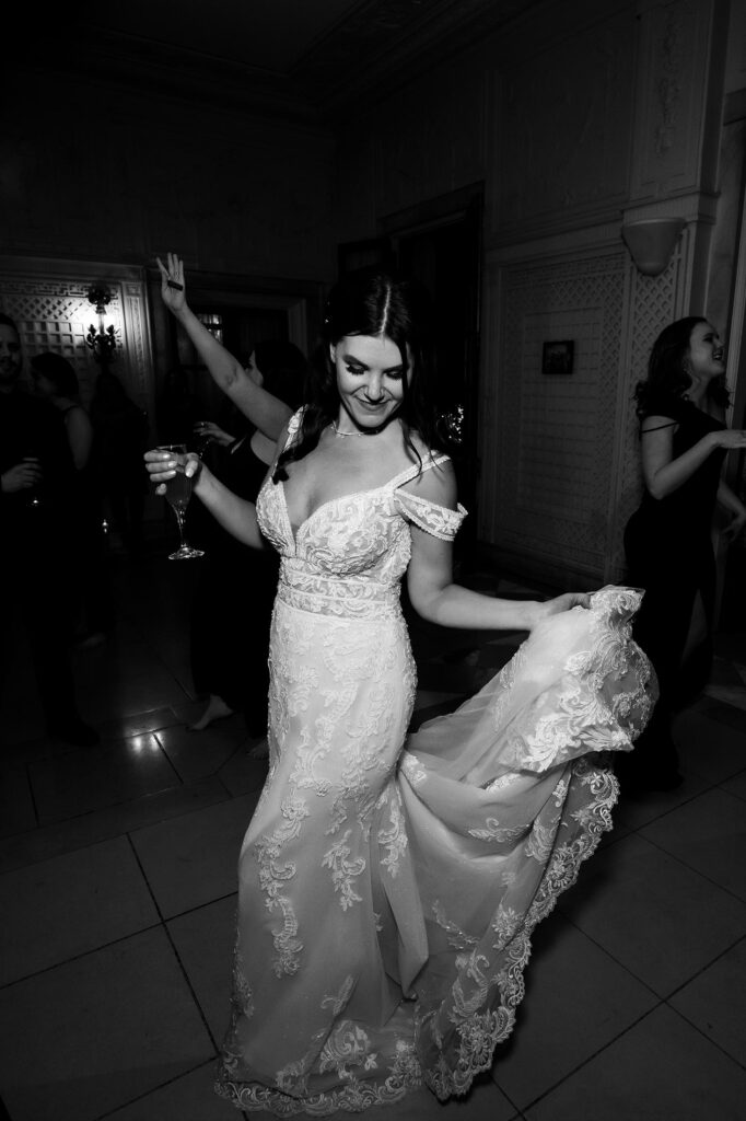 north shore wedding reception bride dancing while holding the train of her dress