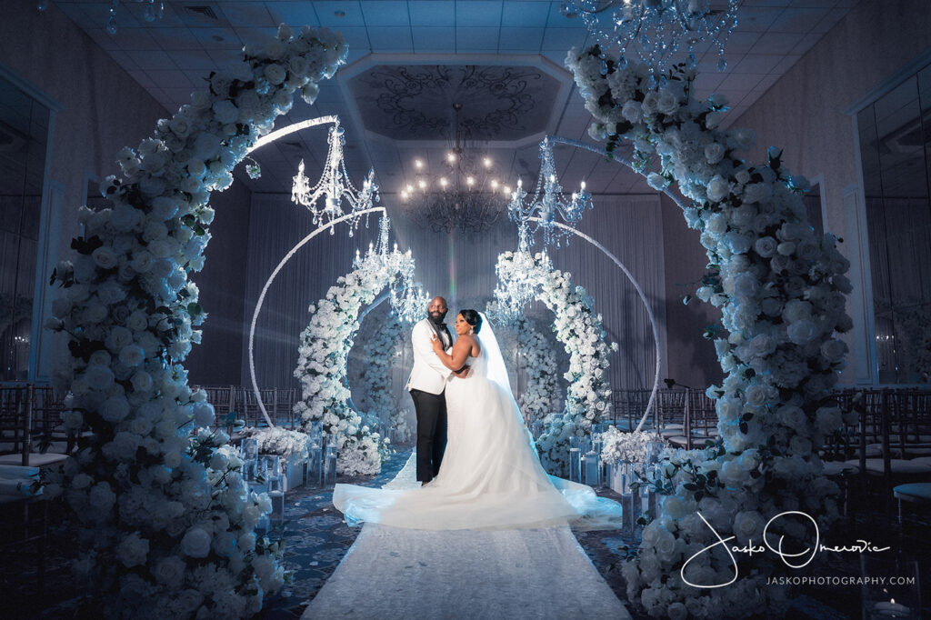 bride and groom surounded by flower arches at meridian banquets wedding venue