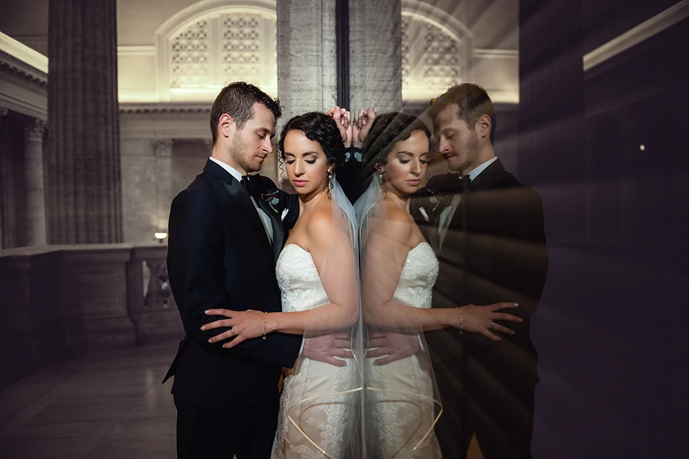 intimate but dramatic image of a couple at their wedding leaning against the window with clear reflections