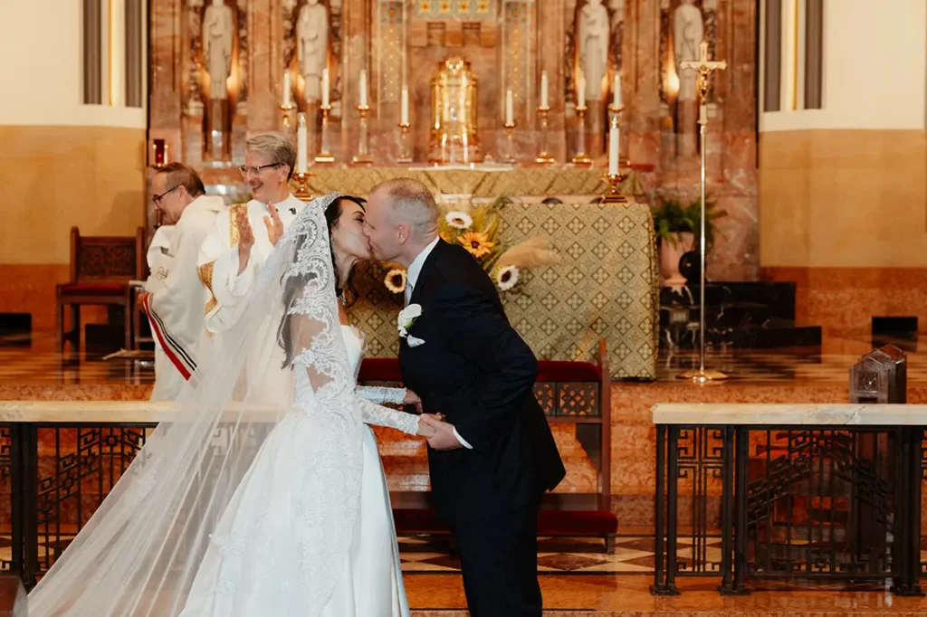 Ashley and James Catholic wedding ceremony first kiss at St. Joseph Church in Wilmette